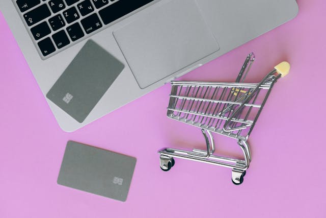 silver-shopping-cart-on-pink-surface