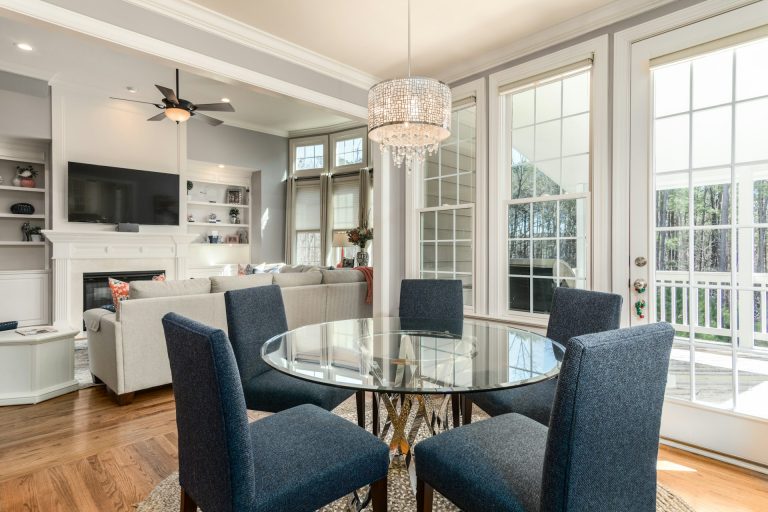 round-clear-glass-top-table-and-five-gray-chairs-dining